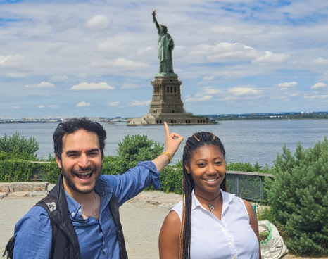 A photo of Twipes cofounders Al and Elle in front of the Statue of Liberty in New York City