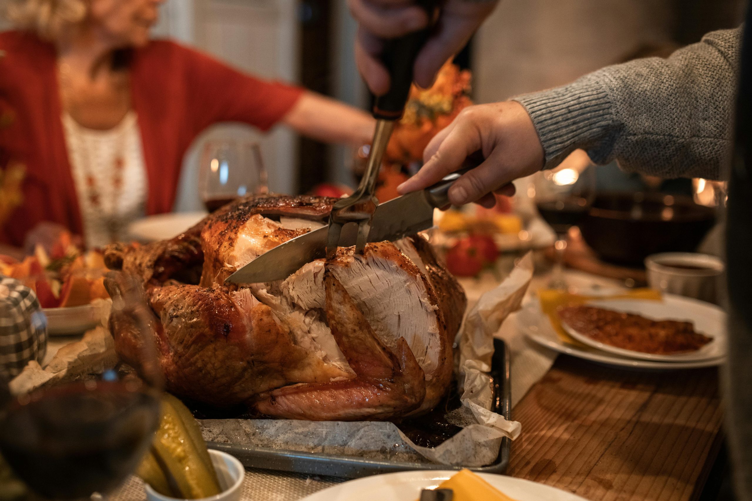 A photo of a person carving a turkey.