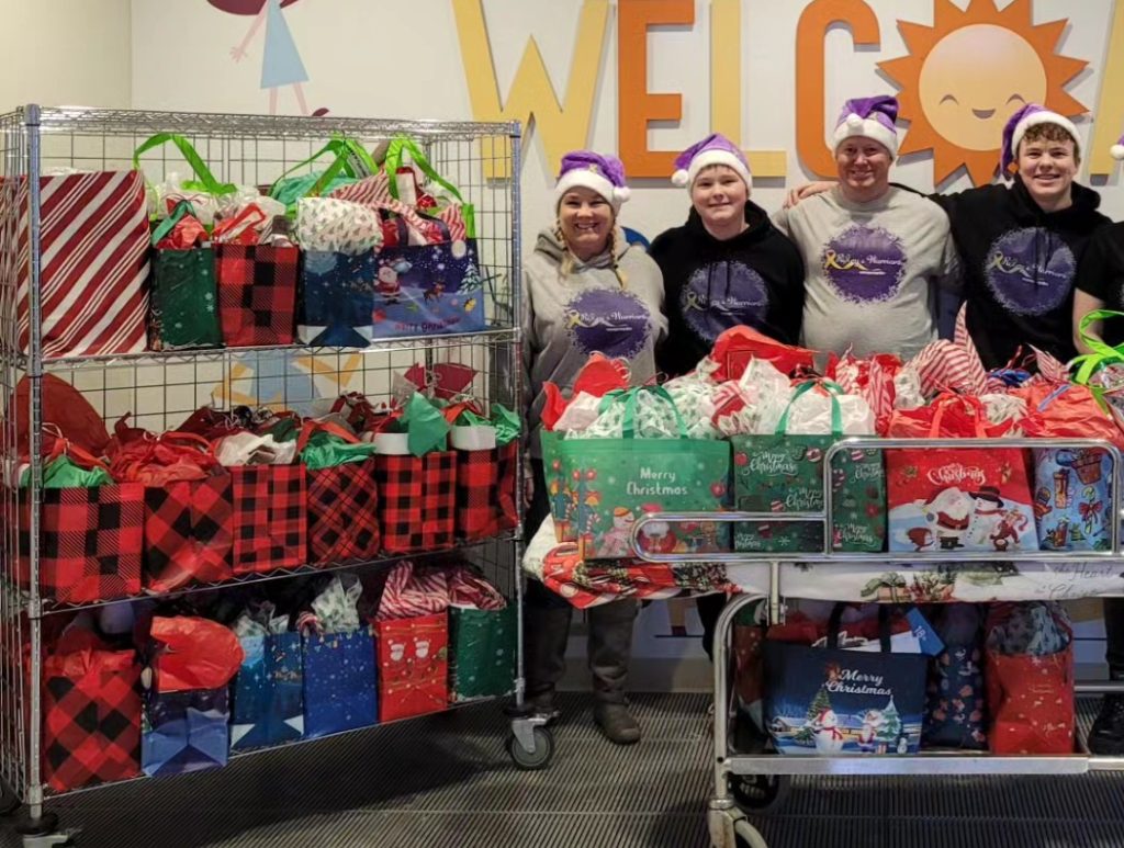 Riley Greene and his family with shelves full of gifts for children in hospitals.